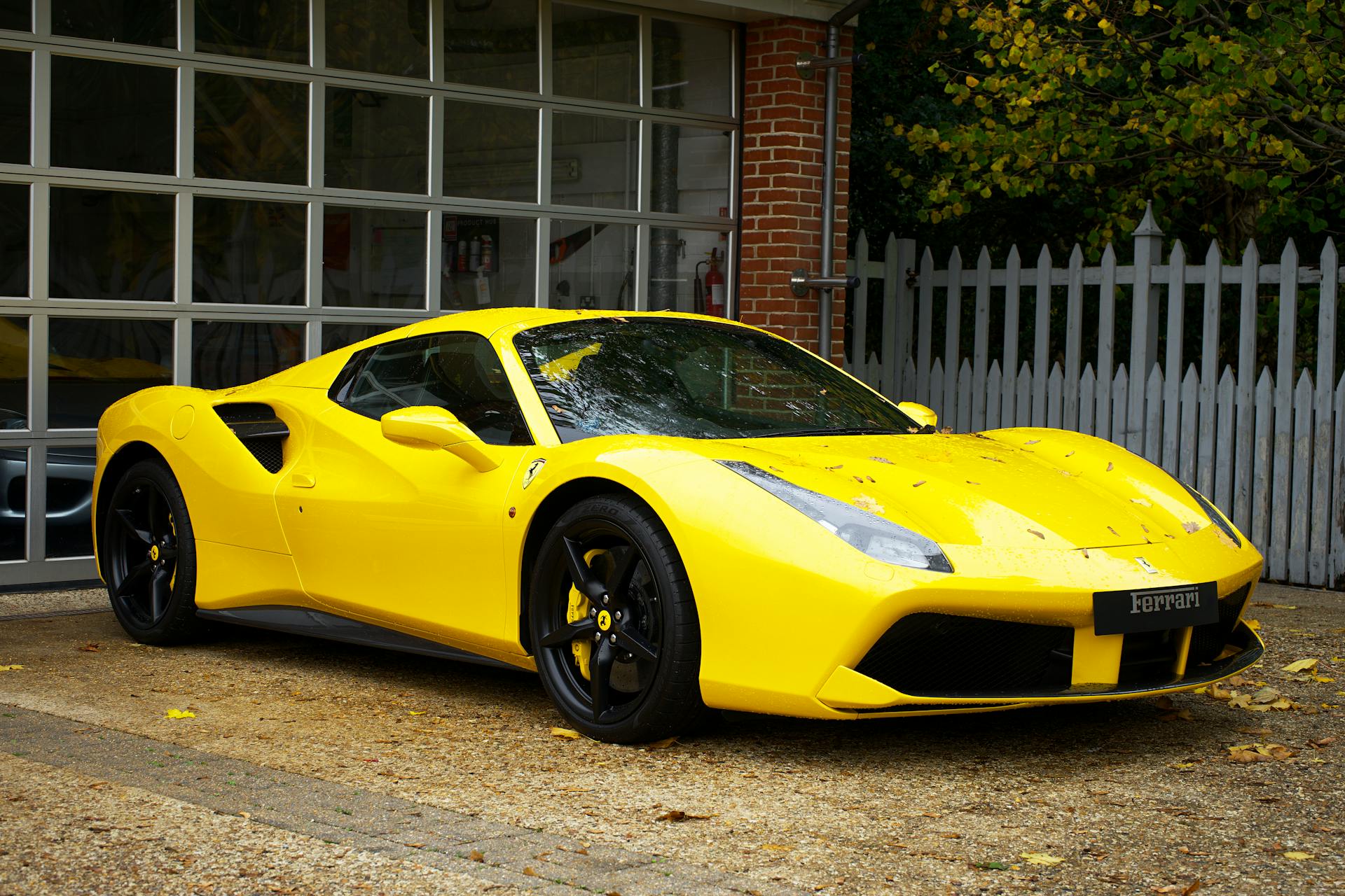 yellow ferrari parked outside garage