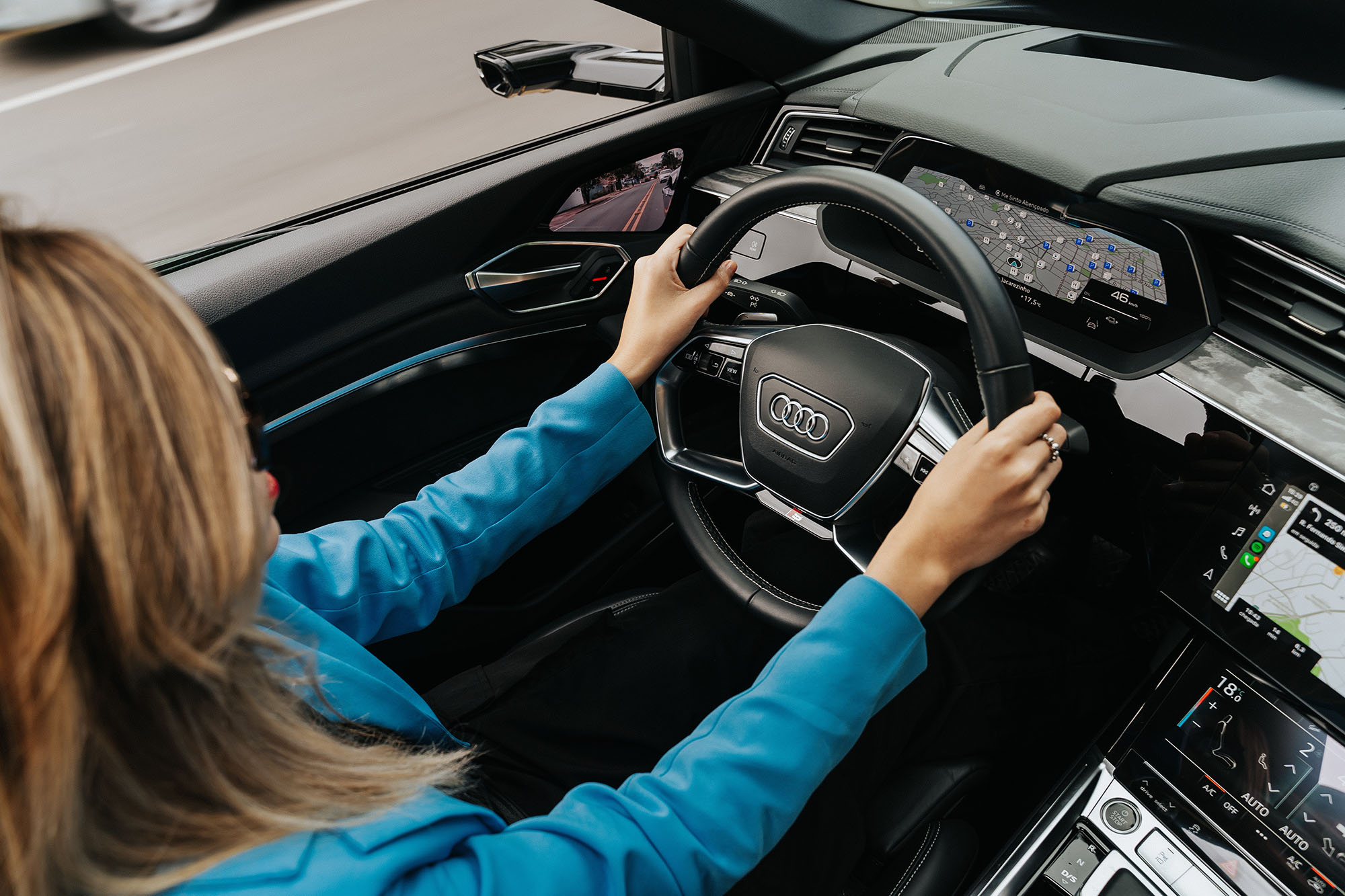 Driver hands on Audi steering wheel with digital dashboard