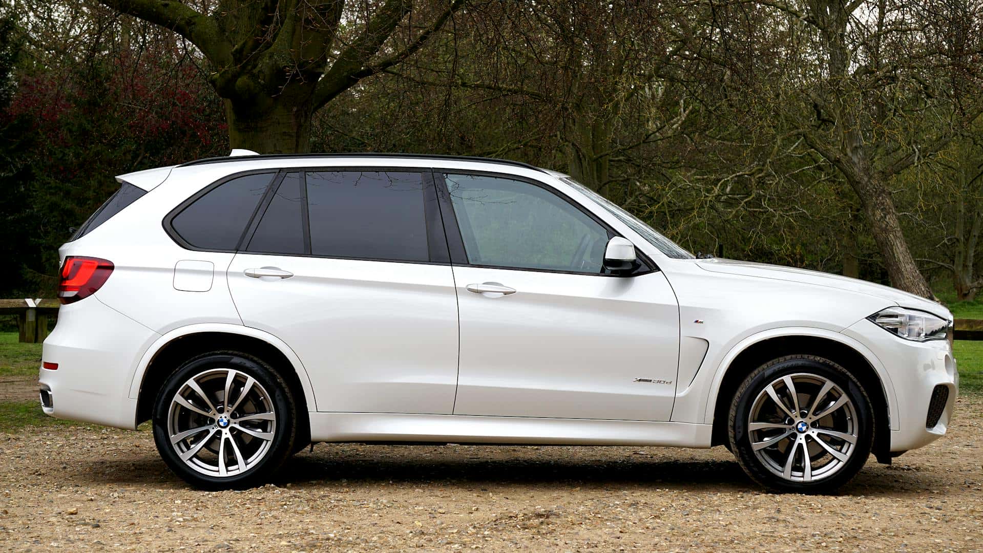 side view of white bmw x5 suv