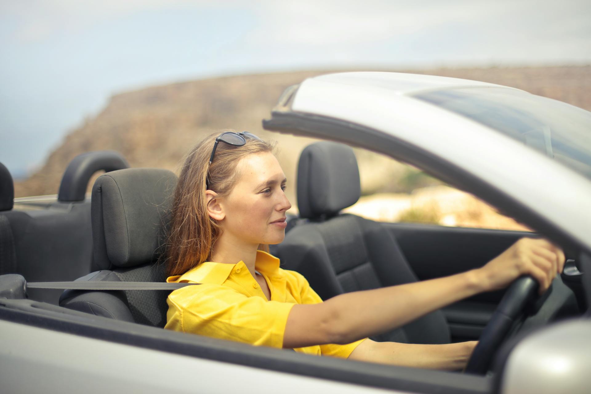 woman happily driving convertible
